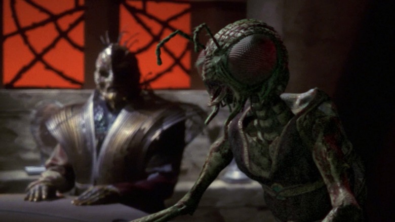 Two Xindi speeces speak at a table