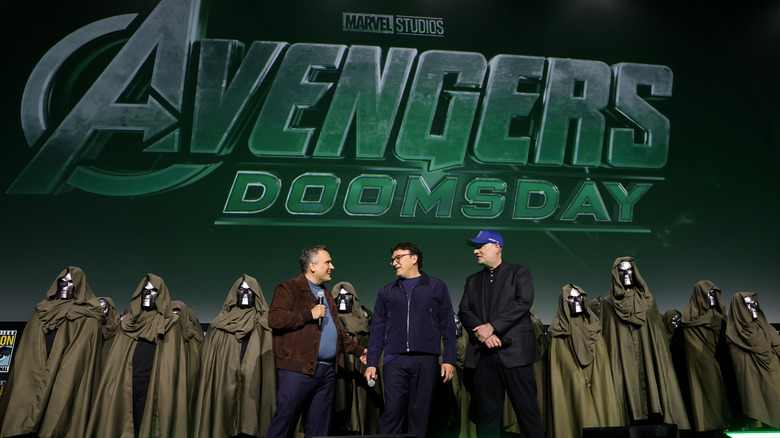 The Russo Brothers announcing "Avengers: Doomday" backed by an army of people dressed as Doctor Doom.