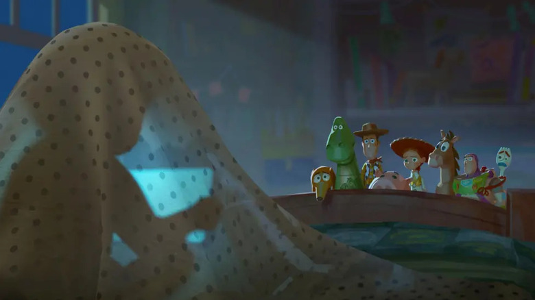 Image from Toy Story 5 showing the toys looking concerned as a child stares at a tablet underneath a blanket.