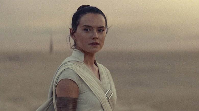 Rey stands on Tatooine smiling