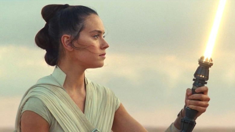 Rey Skywalker igniting her newly-crafted lightsaber on Tatooine in Star Wars: The Rise of Skywalker