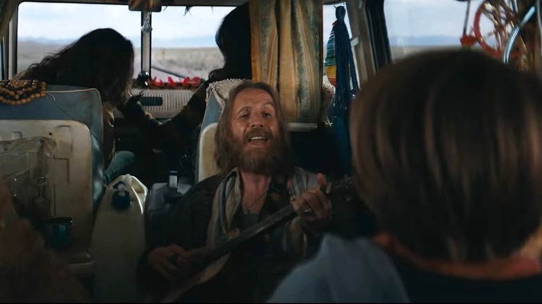 Rhys Ifans character playing guitar