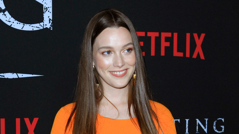 Victoria Pedretti wearing an orange top and smiling