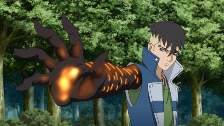 Kawaki holding up his glowing, black hand