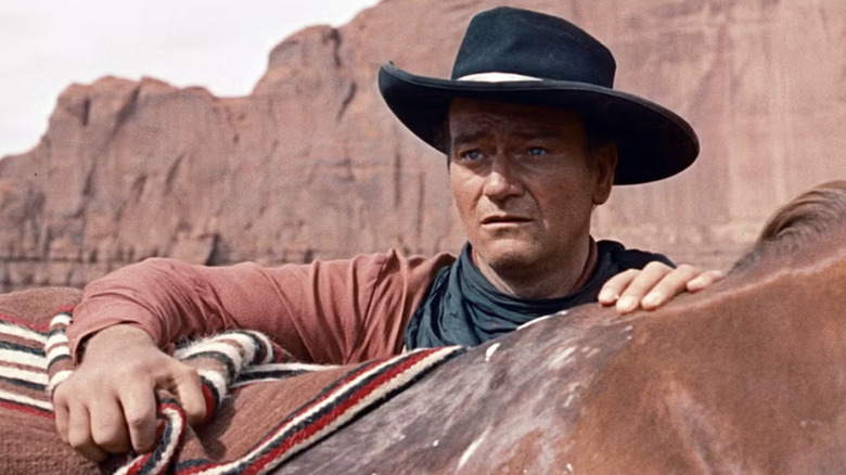 Ethan Edwards looks over his horse at the enemy before him in The Searchers (1956)