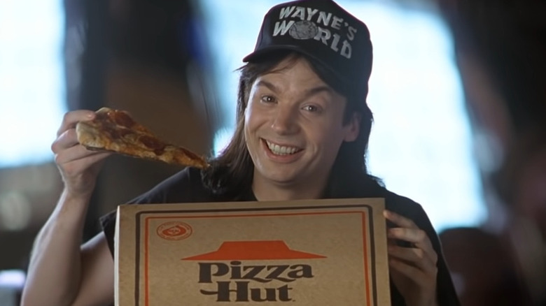 Wayne holding pizza