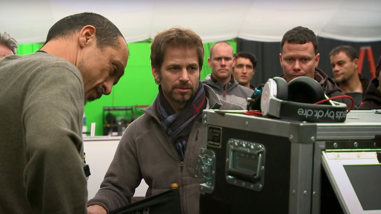 Zack Snyder and crew members watching something on the set of Man of Steel