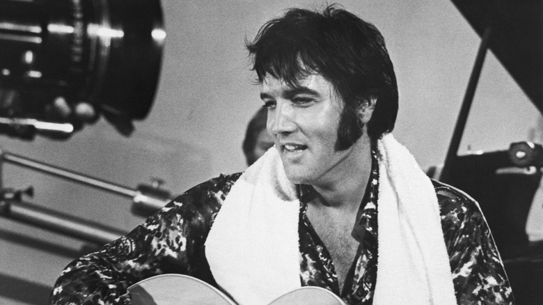 Elvis Presley smiles and holds a guitar (1970)