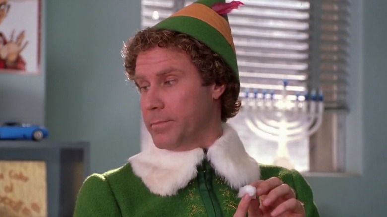 Buddy the Elf holds cotton ball care on finger