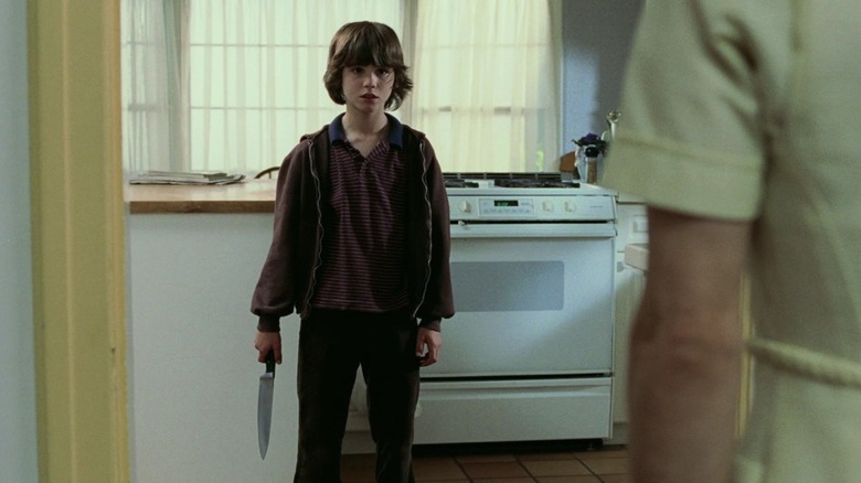 A young Evan stands ominously in the kitchen holding a large knife by his side in "The Butterfly Effect" (2004)