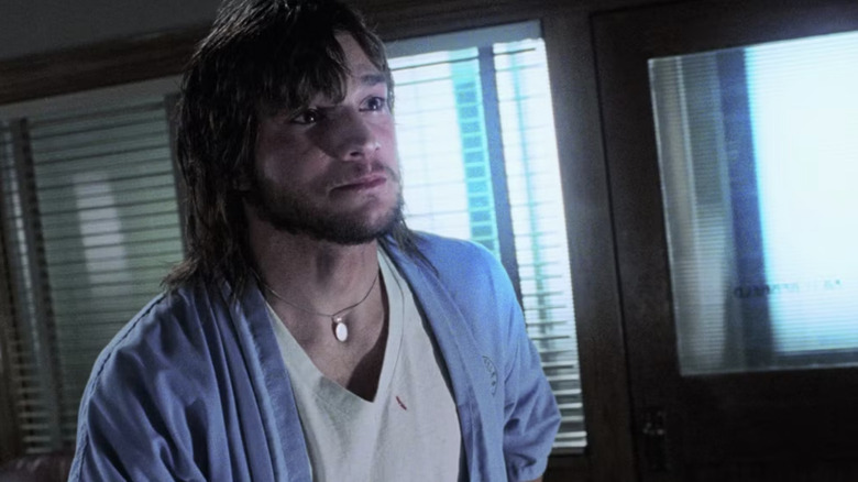 Ethan in a medical gown, looking desparately out a window in "The Butterfly Effect" (2004)