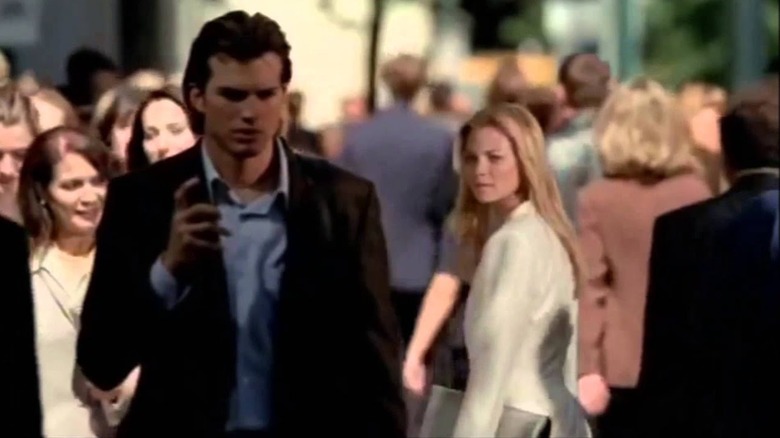 Evan passes Kayleigh on a busy city street and turns to look at her in "The Butterfly Effect" (2004)