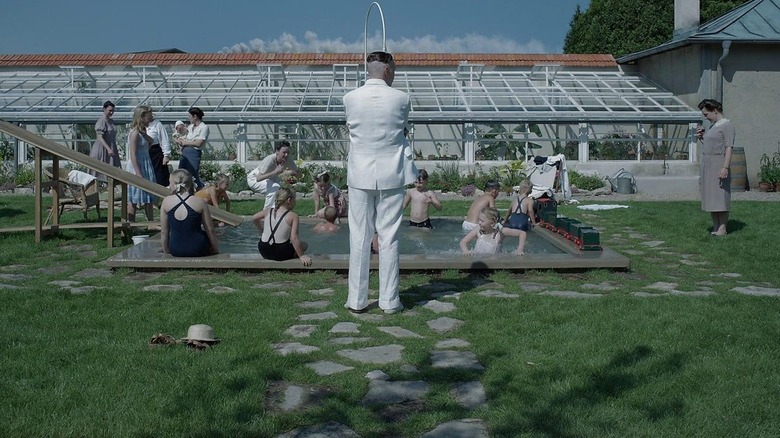 Rudolf Höss stands in front of a pool party in his yard