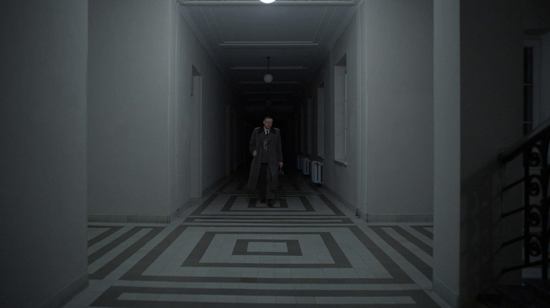 Rudolf Höss walks down a dimly lit hallway