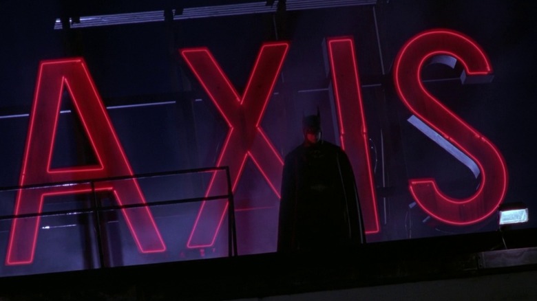 Batman standing by Axis Chemical sign