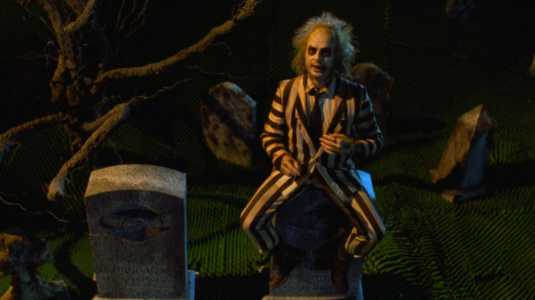 Beetlejuice sitting on tombstone