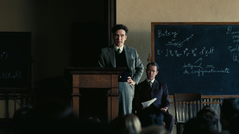 Oppenheimer lectures standing near blackboard