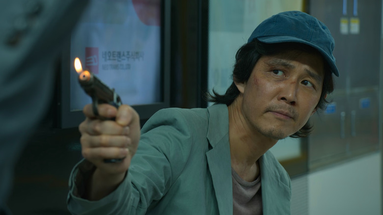 Gi-hun holds a lighter gun on "Squid Game" (2021)