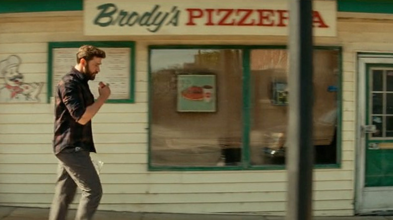 Lee walking by pizzeria