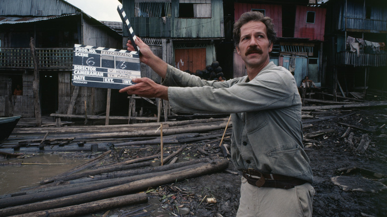 Werner Herzog holding movie clapper