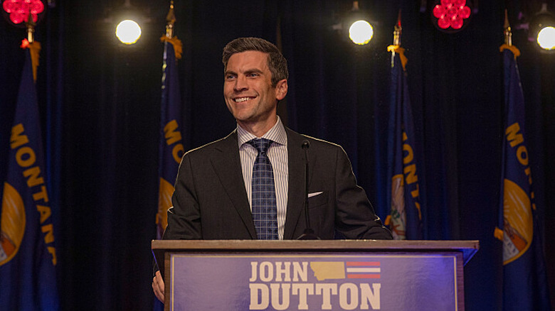 Jamie Dutton smiling at a podium