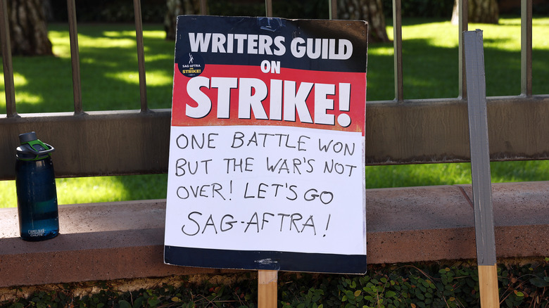 Strike sign leans on fence