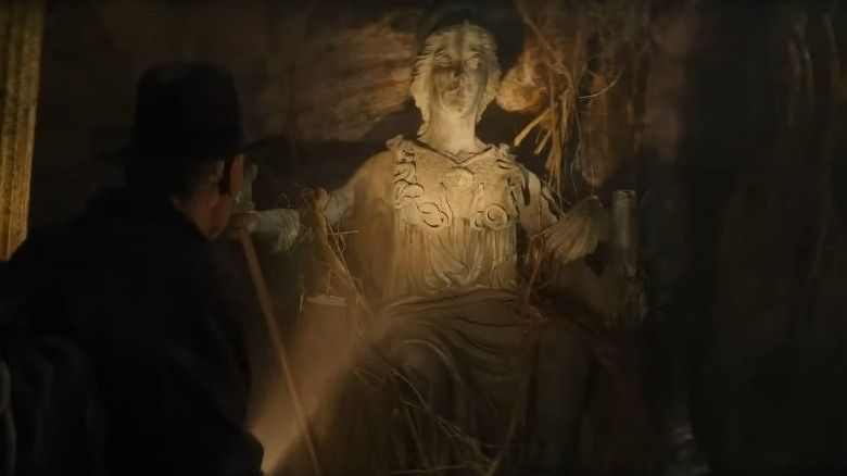 Indiana Jones looking at a statue