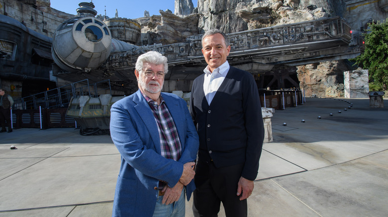 Bob Iger and George Lucas standing in front of the Millennium Falcon