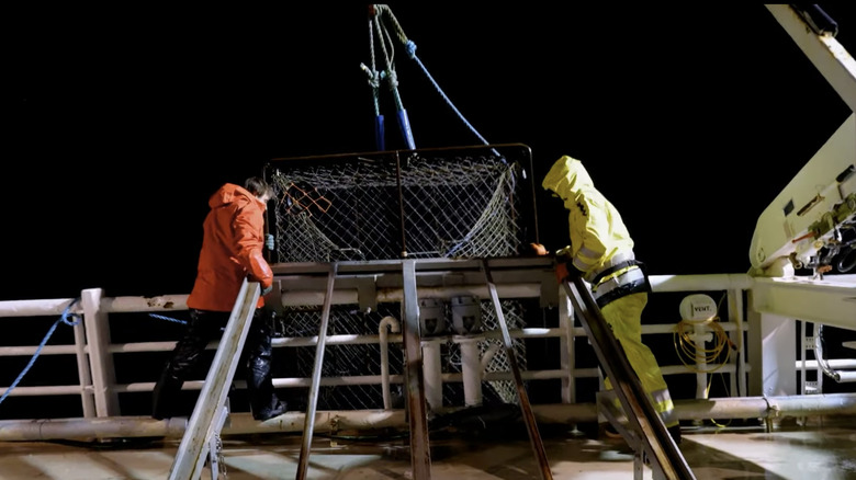 Two deckhands with a crab pot