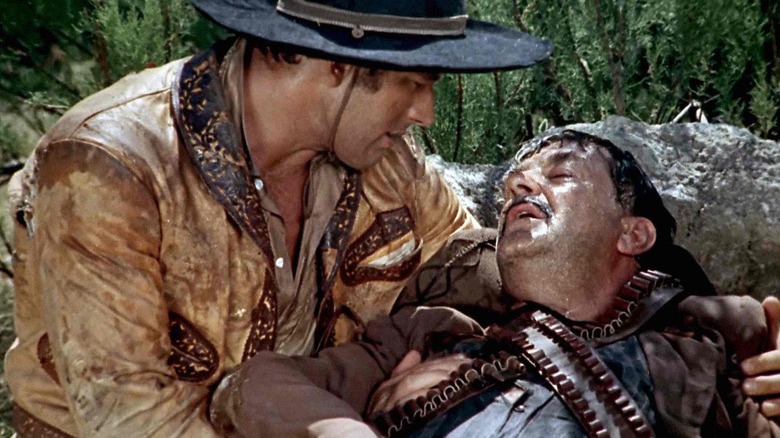 Cowboy comforts a dying man in Gunfight in the Red Sands