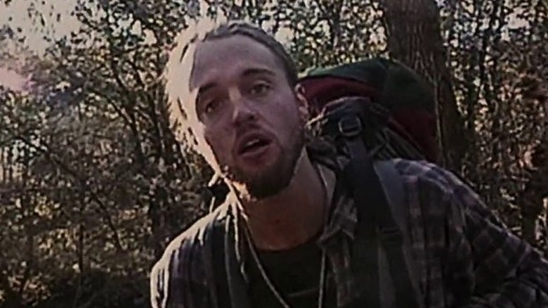 Josh carrying a backpack while hunting the Blair Witch