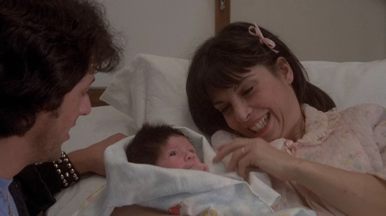 Rocky and Adrian in hospital bed holding their baby