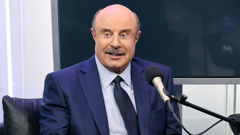 Phil McGraw sitting at microphone