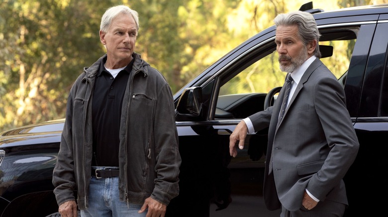 Gibbs and Parker leaning on black SUV