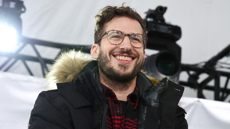 Andy Samberg smiling in a winter coat 