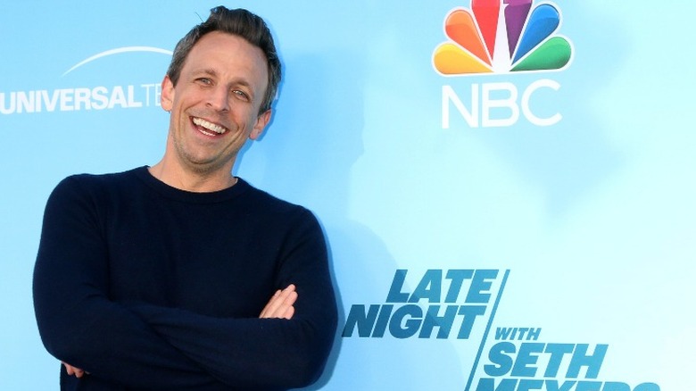 Seth Meyers smiling with arms crossed