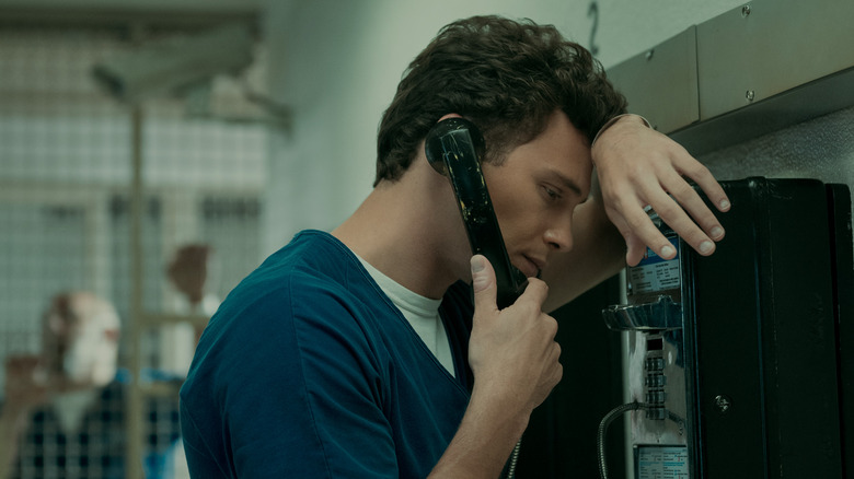 Cooper Koch as Erik Menendez talking on a pay phone from jail in "Monsters: The Lyle And Erik Menendez Story."