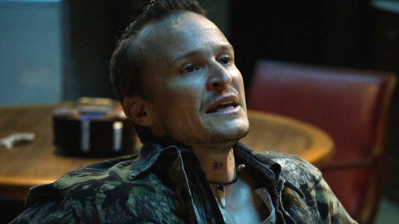 Dewey with his mouth open as he sits in a chair in "Justified."