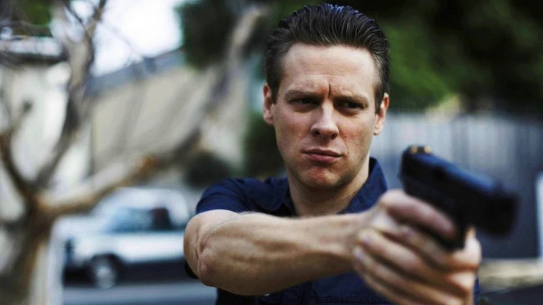 Tim holding a gun while standing outside in "Justified."