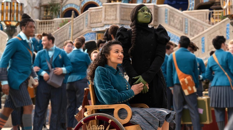 Nessarose holding hands with Elphaba at Shiz University in Wicked