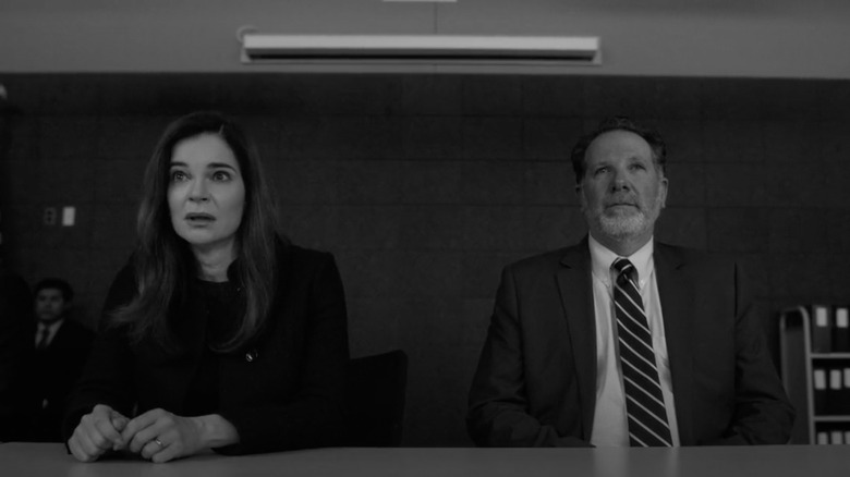 Marie and a federal agent sitting at a table, deposing Saul Goodman