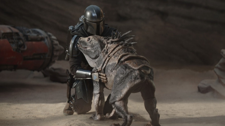 The Mandalorian petting a massiff