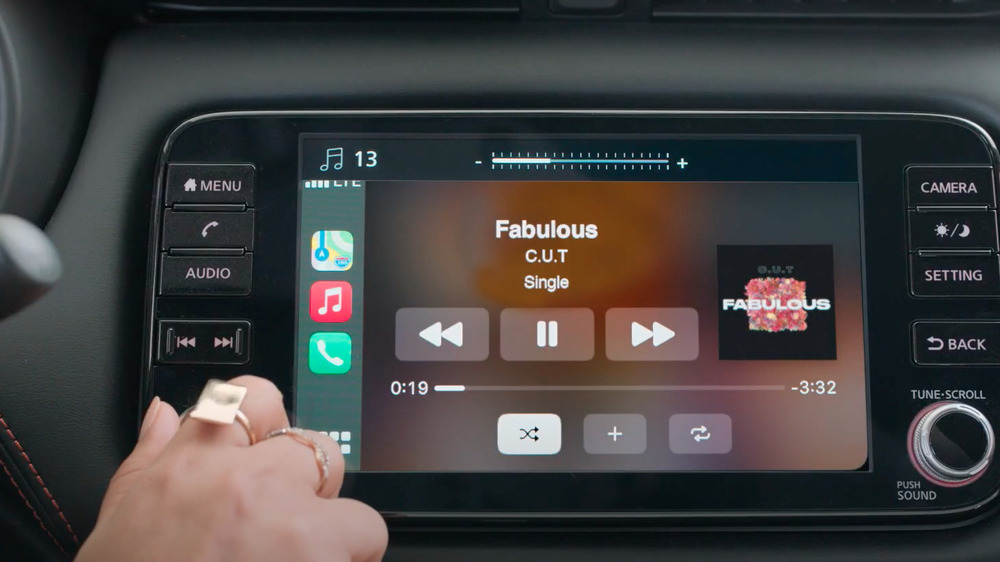 Driver turning up volume on dashboard display in Nissan KICKS commercial 