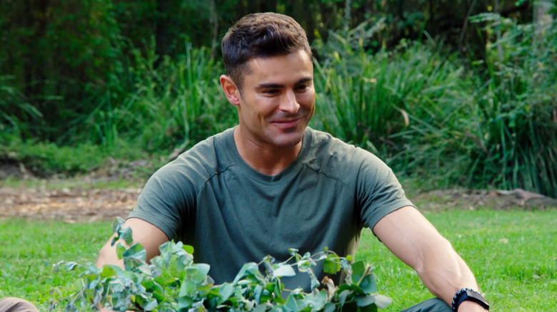 Zac Efron sitting in the grass