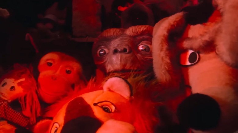 E.T. hiding among stuffed animals