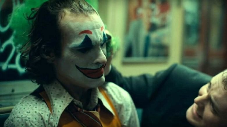 Joker being teased by one of the Wayne executives