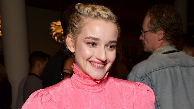 Julia Garner smiing in pink dress