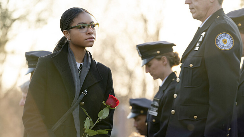 Carrie holding rose at funeral