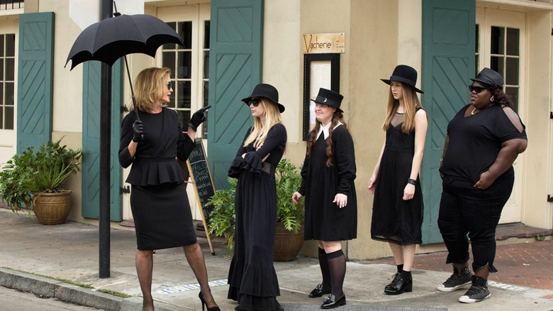 Women dressed in black line up on a street corner