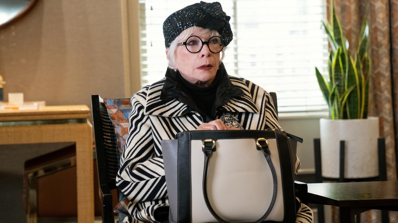 Shirley MacLaine as Leonora sitting in chair